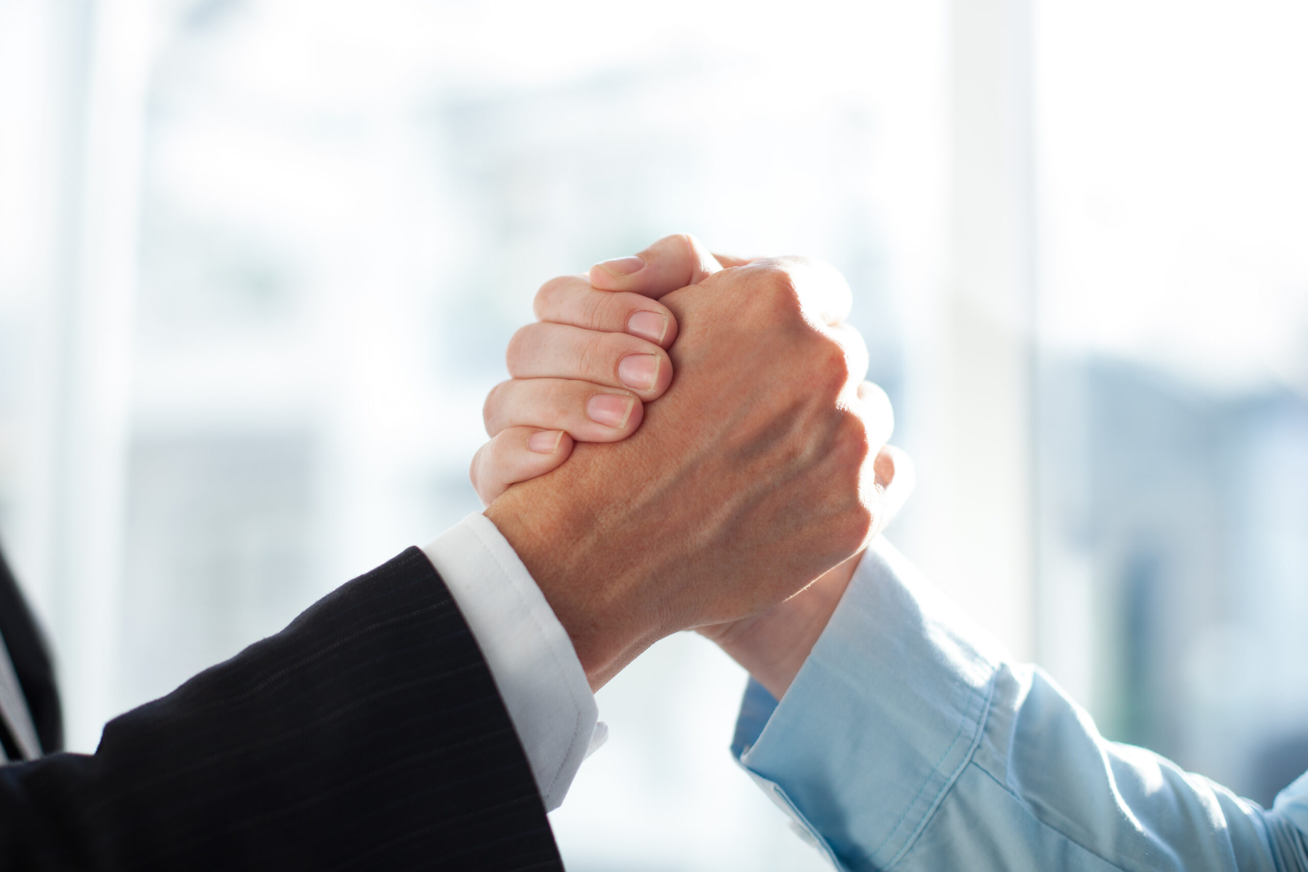 Close-up of two clasped hands of businessmen <a href="https://www.freepik.com/free-photo/agreement-team-friend-collar-white_1027058.htm#query=promise&position=9&from_view=search&track=sph">Image by katemangostar</a> on Freepik